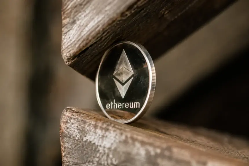 Ethereum coin balanced between two wooden surfaces in close-up